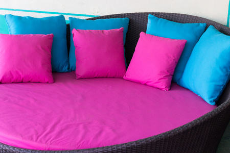粉色和蓝色棕色藤沙发上的枕头图片