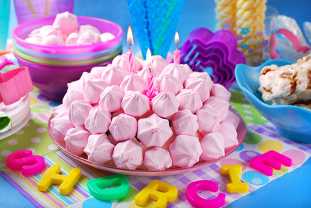 用粉红色的蛋酥和蜡烛的生日蛋糕
