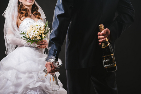 婚礼情侣接吻和喝香槟。黑色背景