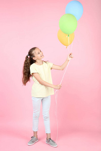 粉红色背景的彩色气球可爱的年轻女孩