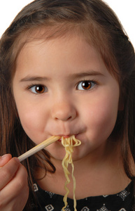 年轻的女孩吃面条汤
