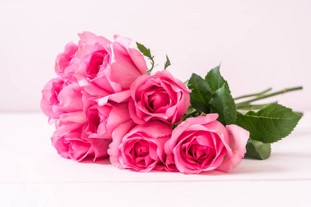 粉红色的玫瑰在花瓶上的木材背景与复制空间
