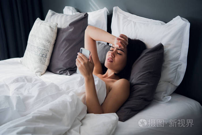 照片 生病的美丽的女人躺在床上高热.