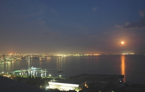 在夜间和在水中的月亮反射的巴库市