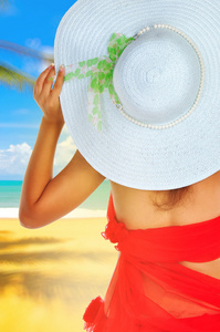 夏季假期女人戴着帽子的海滩上