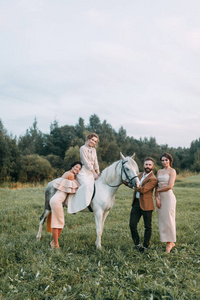 婚礼在美国风格, 在牧场上有匹马。在日落时分, 与朋友和马背上的情侣在田野散步。现代夫妇和仪式的想法