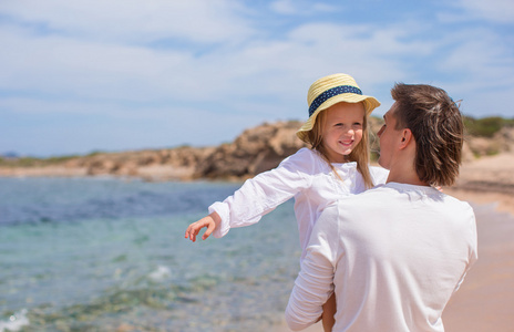 快乐的父亲和可爱的小女儿在海滩度假的乐趣