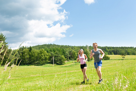 慢跑的草甸阳光灿烂的夏天运动年轻夫妇
