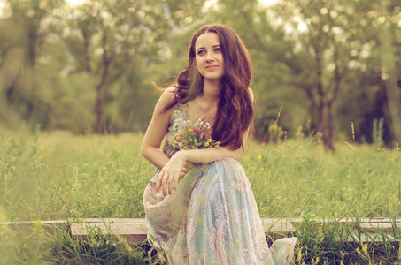 漂亮的女孩坐在草地上