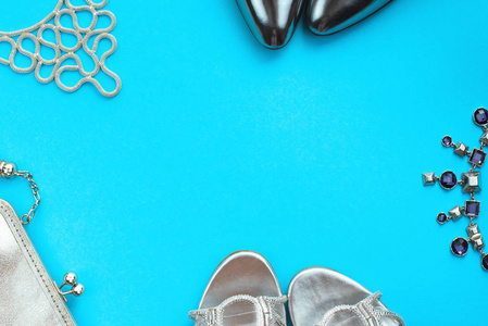套装时尚饰品平躺鞋手袋项链饰品银色颜色在蓝色背景上查看复制空间