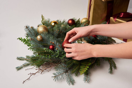 妇女装饰圣诞节杉木花圈与查出的玩具的裁剪图像白色