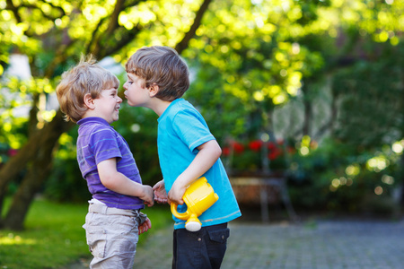 两个小的同级男孩拥抱和在户外玩得开心