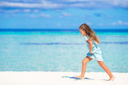 可爱的小女孩，在热带的白色海滩上运行