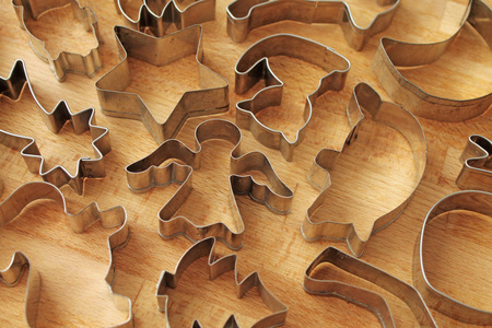 不同的饼干形式在木制背景。饼干烘焙用金属模具