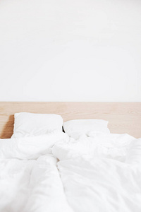 床上有干净的白色床单和白色墙壁。公寓出租概念。内部