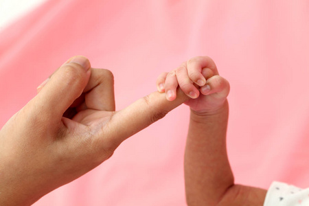 新生儿的手紧握父母的手指