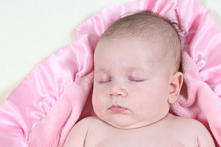 在张粉色的毯子睡觉的小宝贝