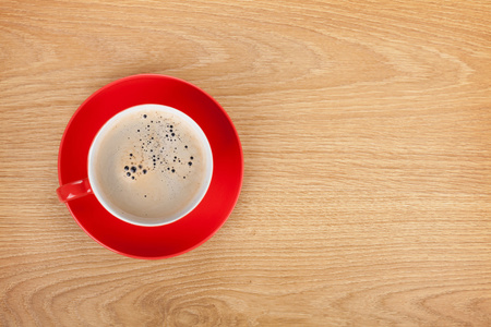 木制的桌子上的红色咖啡杯