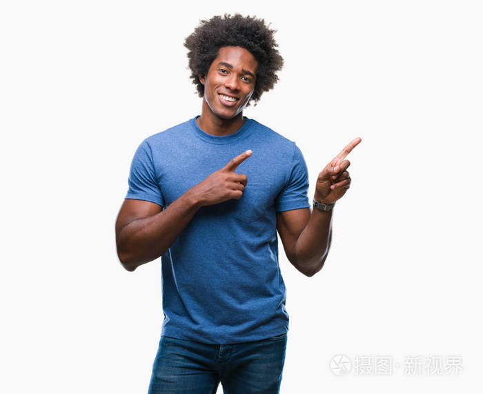 美国黑人在孤立的背景下微笑着, 看着相机指着两只手和手指的侧面