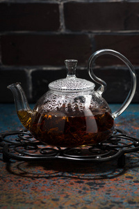 茶玛莎在一个玻璃茶壶在黑暗背景, 垂直特写镜头