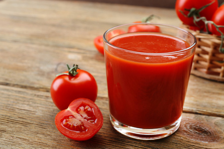 杯木制背景上新鲜的番茄汁