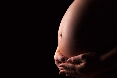怀孕的女人剪影在黑色的背景