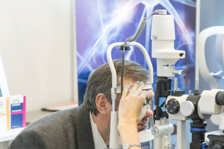病人眼科医生用器械检查病人的眼睛。医疗保健, 医学, 人, 视力和技术概念人检查他的视力机器检查病人