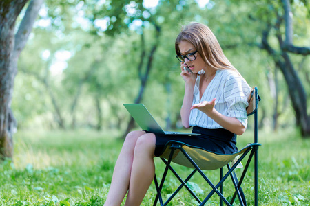 商业妇女使用笔记本电脑在午餐休息在城市公园
