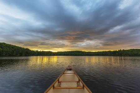 在加拿大的湖，在日落的独木舟弓