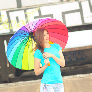 彩虹伞在房子的屋顶上的女孩