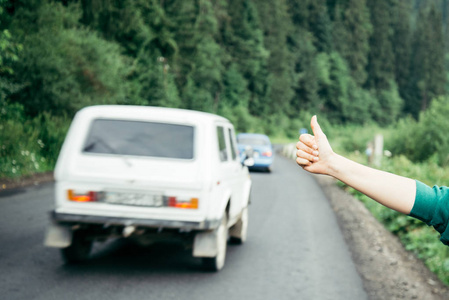 徒步旅行者在农村山区公路的女人的手