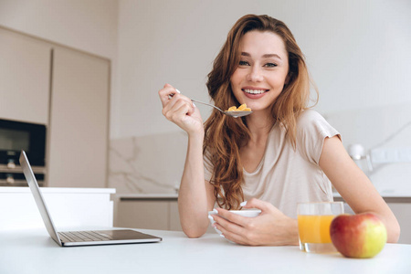 情感漂亮的女人在厨房里吃水果沙拉