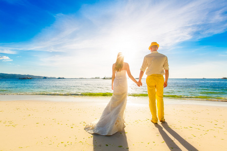 新娘和新郎在黑色中的落日的热带海滩上熱帯背景隠夕日新郎新婦