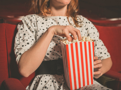 年轻女人在电影院吃爆米花