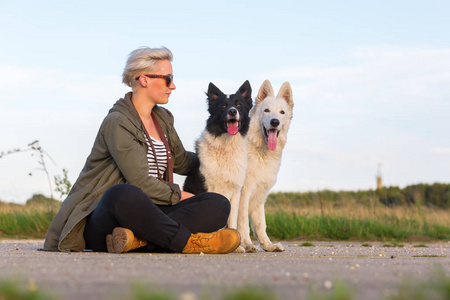 白色的德国牧羊犬与边境牧羊犬的女人