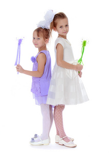 两个穿着考究的女孩抱着一根魔杖