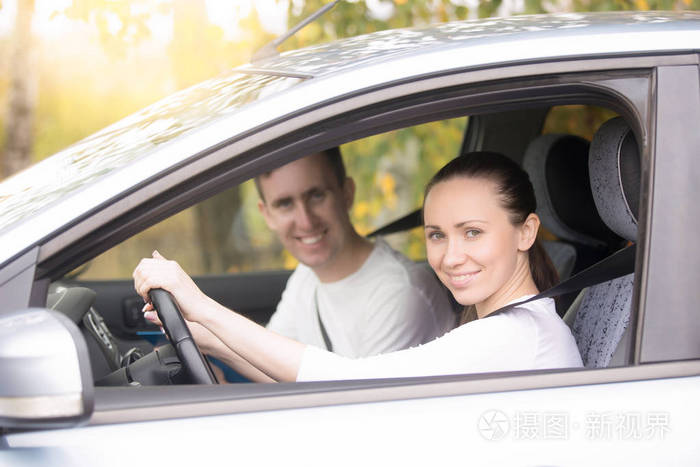 年轻女子开车,一个人坐在车里附近