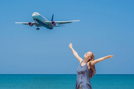 海滩上的年轻女子和落地飞机。旅游理念