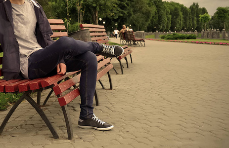 一个男孩坐在公园的长凳上