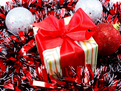 礼品盒目前用红丝带装饰以红色和白色的金属箔圣诞节背景