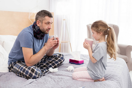 生病的爸爸和他的女儿喝热茶