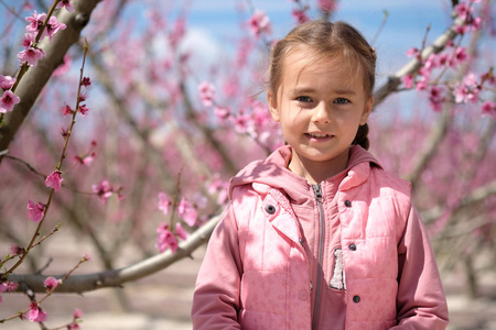可爱的小女孩在树丛中的果树。西班牙