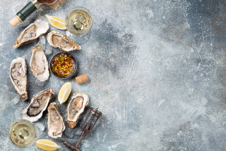 石桌上的新鲜牡蛎和白葡萄酒。具有文本空间的顶部视图