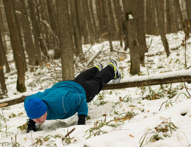 在冬季树林里的人执行锻炼
