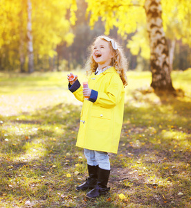 笑小女童在晴朗 温暖身穿黄色外套