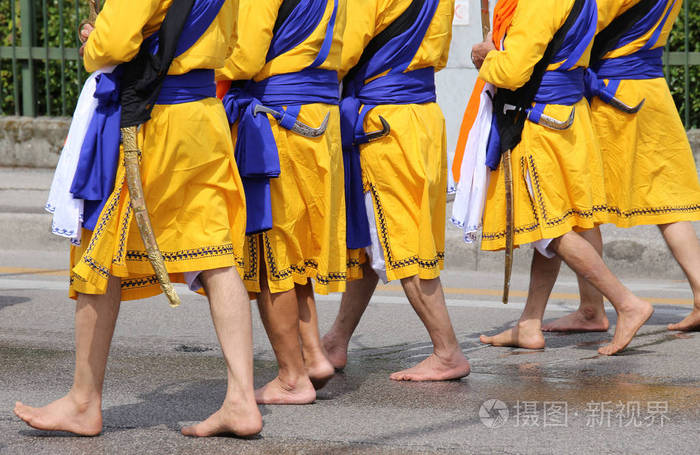 五名男子与赤脚走在街道上的长裙子