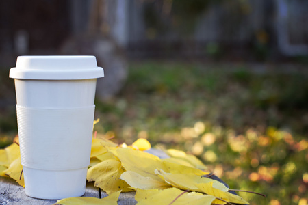 杯咖啡和黄色的秋天的树叶
