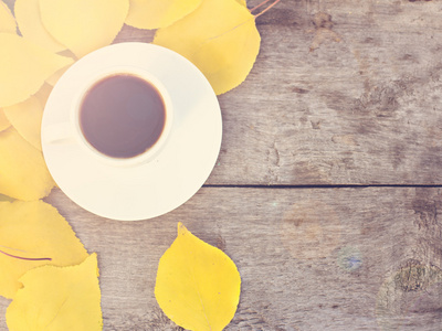 杯咖啡和黄色的秋天的树叶