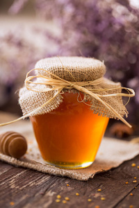天然的蜂蜜。蜂蜜在玻璃罐子背景