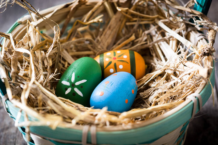 在木制的桌子上一篮子的复活节彩蛋